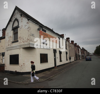 Eine Frau geht Vergangenheit verschalten Häuser auf Travers Street Middleport stoke on-trent Stockfoto