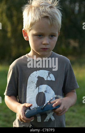 Porträt von blonden Jungen Kind junge fliegen ein remote gesteuerten Modell Flugzeug Stockfoto