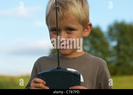 Porträt von blonden Jungen Kind junge fliegen ein remote gesteuerten Modell Flugzeug Stockfoto