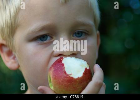 Kind Blondschopf im Apfel beißen Stockfoto