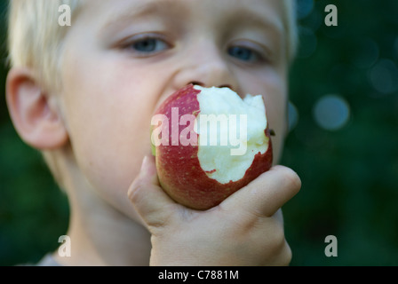 Kind Blondschopf im Apfel beißen Stockfoto