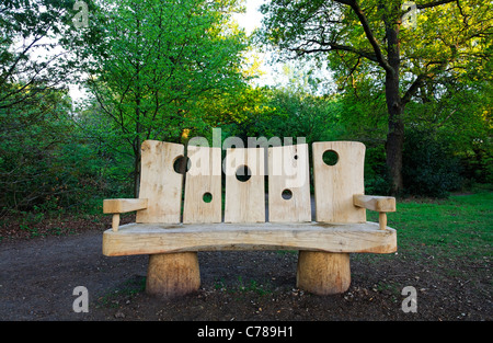 Eine geschnitzte Holzbank am Burnham Beeches, Buckinghamshire, England Stockfoto