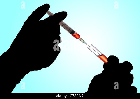 Hand hält eine Spritze und Blutentnahme aus der Tube für die Analyse Stockfoto