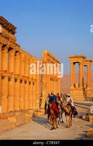 Touristen, Kamelreiten entlang der Colonnaded Straße, Palmyra, Syrien Stockfoto