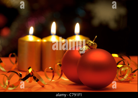 Weihnachtskerzen und rote Kugeln. Eine festliche Komposition Stockfoto