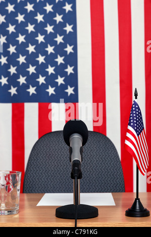 Foto eines amerikanischen thematische Konferenz-Desk mit Mikrofon und Fahnen. Stockfoto