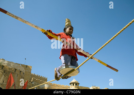 Ein Kind Acrobat führt am Eingang zum Jaisalmer Fort in der Wüste Thar im indischen Bundesstaat Rajasthan liegt Fort Tor Stockfoto