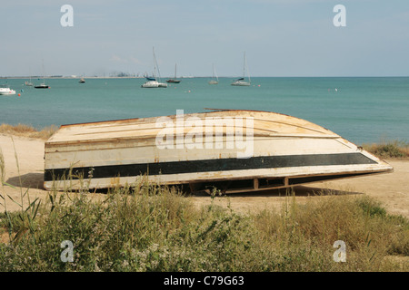 Alte Boot kopfüber am Strand liegen. Stockfoto