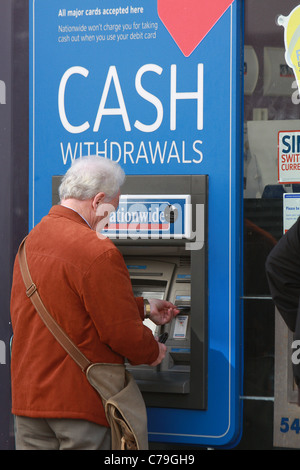 Ein Mann zieht sich Bargeld aus einem bundesweiten ATM Stockfoto