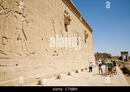 Eine Tourguide hält Vorträge über die Reliefs der berühmten Kleopatra VII. an der Außenwand des Tempel der Hathor in Dendera Stockfoto