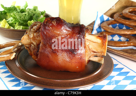 frisch gebratenes Schweinefleisch Hock mit Weißbier, Brezeln und Salat Stockfoto
