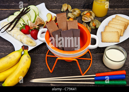 frische Zutaten für ein typisches Schweizer Schokoladen-Fondue mit Obst und Gebäck Stockfoto