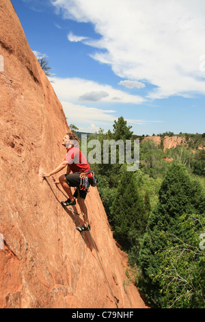 ein Mann in der roten Führung auf einem Sandstein Platte Klettern Stockfoto