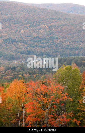 Ein Kirchturm ist sichtbar unter das bunte Laub in den Vermont Hügeln. Stockfoto