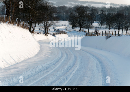 Land straße im Schnee, heckenlandschaft der Normandie, in der Nähe von Mont Margantin (Domfrontais, Orne, Normandie, Frankreich). Stockfoto