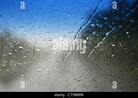 Blick durch einen nassen Windschutzscheibe mit flachen Schärfentiefe und Fokus auf die Wassertropfen Stockfoto