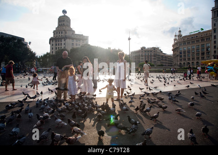 Menschen, die Fütterung von Tauben auf der Placa de Catalunya, Barcelona, Spanien Stockfoto