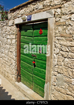 Grüne traditionelle Tür auf Steinwand, Insel Susak, Kroatien Stockfoto