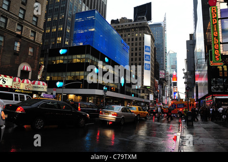 Verkehr Menschen blue Neon Barclays Bank, rote Applebee Zeichen, nassen Regen Asphalt 7th Avenue Richtung Times Square in New York City Stockfoto