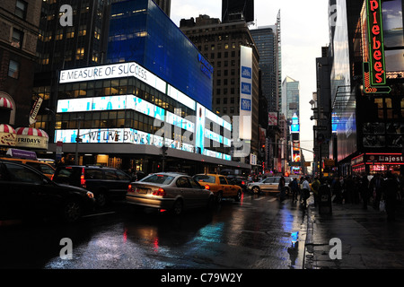 Nassen verregneten Asphalt Ansicht Verkehr Menschen rote Applebees blau-weißen Barclay Neon signs, 7th Avenue, in Richtung Times Square in New York Stockfoto