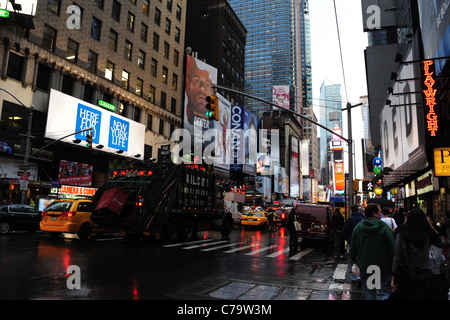 Regen nassen Asphalt Reflectionsview Autos gelbe taxis Müll Wagen Neon Wolkenkratzer, 7th Avenue Richtung Times Square in New York City Stockfoto