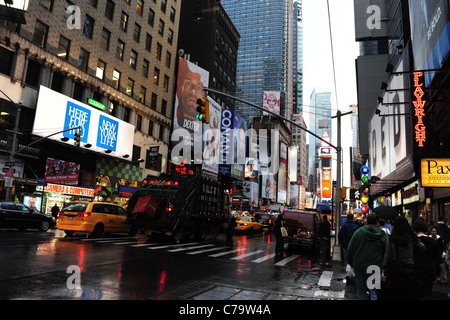 Nassen Asphalt Regen Reflexion Autos gelben taxis Müll Wagen Neon Werbung Wolkenkratzer 7th Avenue, Richtung Times Square in New York City Stockfoto