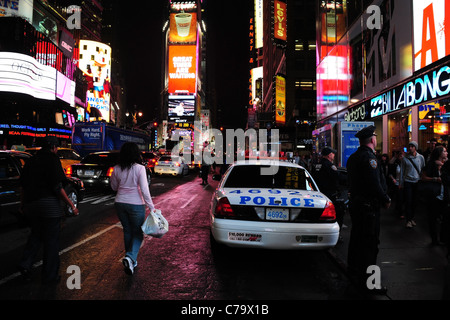 Nacht-Ansicht Bürgersteig Polizisten, geparktes Polizeiauto, Menschen gehen, Verkehr, Neon, 7th Avenue, Times Square, New York City, USA Stockfoto