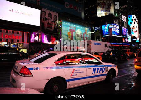 Nachtansicht des weißen NYPD Streifenwagen geparkt auf der Seite des 7th Avenue vor Leuchtreklamen, Times Square, New York City Stockfoto