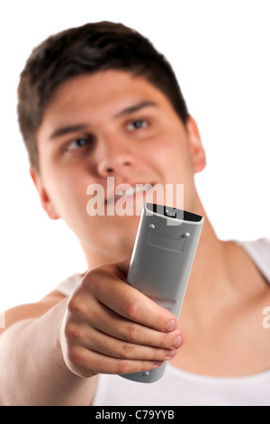 Ein Teenager ändert den Kanal mit der Fernbedienung über einen weißen Hintergrund isoliert. Geringe Schärfentiefe. Stockfoto