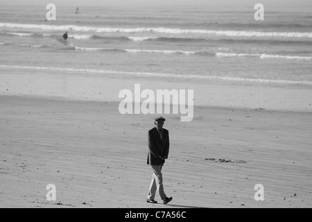 Schwarz-weiß Foto von älteren Herrn mit künstlichen Hände wandern am Strand von Muizenberg in der Nähe von Kapstadt. Stockfoto