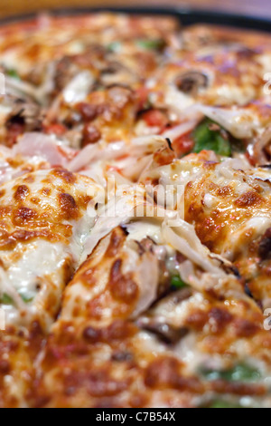 Eine frische hausgemachte Spezialität Pizza mit extra Belag heiß und frisch aus dem Ofen. Geringe Schärfentiefe. Stockfoto