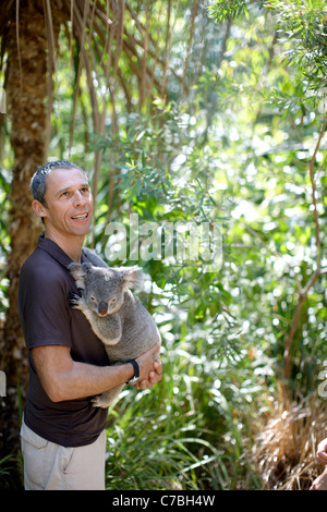 Touristen halten einen Koala im Bungalow Bay Koala Dorf Horseshoe Bay Nordküste von magnetischen Insel Great Barrier Reef Marine Park Stockfoto