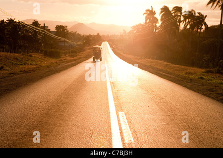 Pferdekutsche auf der Straße bei Sonnenuntergang, in der Nähe von Sancti Spiritus, Sancti Spíritus, Kuba, Karibik Stockfoto