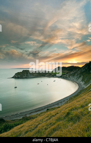 Eine Ansicht von Lulworth Cove, Teil der Jurassic Coast in Dorset bei Sonnenuntergang mit Portland Bill in der Ferne Stockfoto