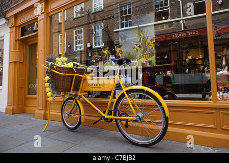 Alten Stil gelb Kaufmann Fahrrad vor Geschäft in York, England Stockfoto