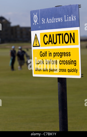 Vorsicht Zeichen und Golfer. Melden Sie bei den alten Golfplatz in St. Andrews, die Vorsicht Mitteilung Warnung zu kümmern und schnell überqueren Stockfoto