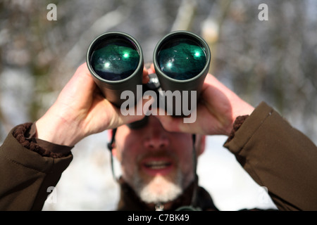 Lächelnder Mann Blick durch ein Fernglas Stockfoto