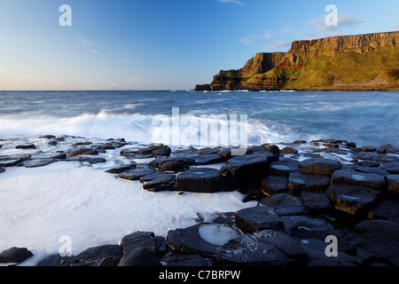 Wellen plätschern über Basaltsäulen in der Nähe von Sonnenuntergang, Giant es Causeway, County Antrim, Nordirland, Vereinigtes Kingdon Stockfoto