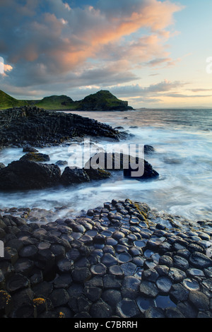 Wellen plätschern über Basaltsäulen in der Nähe von Sonnenuntergang, Giant es Causeway, County Antrim, Nordirland, Vereinigtes Kingdon Stockfoto