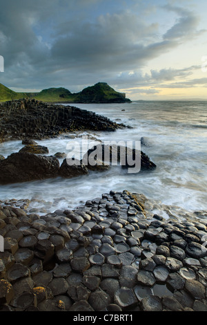 Wellen plätschern über Basaltsäulen in der Nähe von Sonnenuntergang, Giant es Causeway, County Antrim, Nordirland, Vereinigtes Kingdon Stockfoto