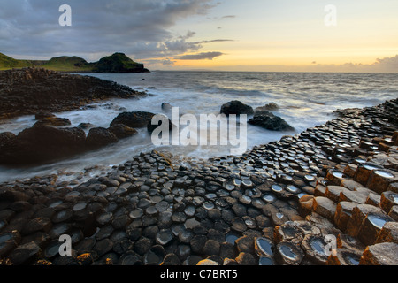 Wellen plätschern über Basaltsäulen in der Nähe von Sonnenuntergang, Giant es Causeway, County Antrim, Nordirland, Vereinigtes Kingdon Stockfoto