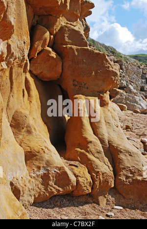 Strand und Klippen bei Burton Bradstock Dorset England zeigt Ergebnis der Seeabnutzung auf weichem Sandsteinfelsen Stockfoto