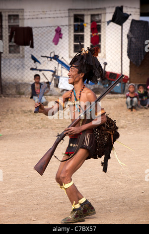 Indien, Nagaland, Longwa, Konyak Naga Krieger in traditioneller Kleidung, mit der Hand gemacht Schnauze Pistole laden Stockfoto