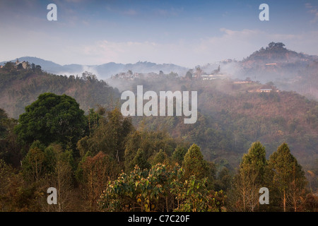 Indien, Nagaland, Mann, Nebel am frühen Morgen über Hang Häuser Stockfoto