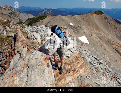 Backpacker raufkraxeln Rock Ridge, Bailey Bereich durchqueren, Olympic Mountains, Washington Stockfoto