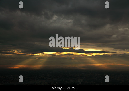 Sonnenstrahlen, die durch ein dunkel bewölkter Himmel platzen Stockfoto