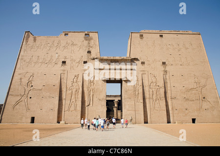Touristen am ersten Pylon des Tempels von Horus in Edfu, Ägypten Stockfoto