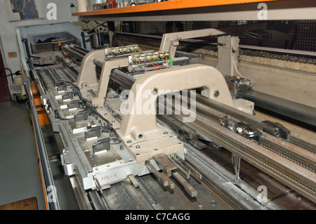 Beförderung von einem industriellen Flachbett Strickmaschine Stockfoto