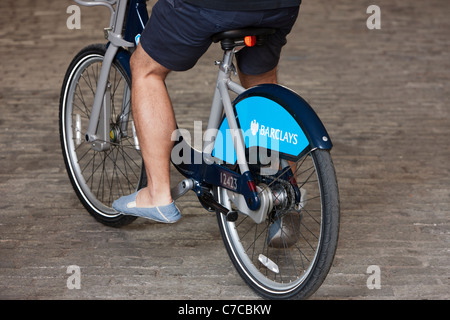 Ein Radfahrer versucht ein Fahrrad vom Londoner Fahrrad Share Programm, gesponsert von Barclays. Stockfoto