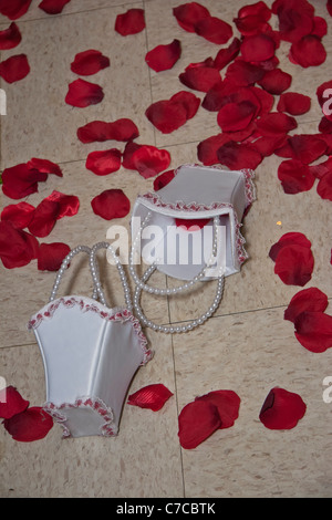 Lose rote Rosenblätter verteilen sich während des Hochzeitsempfangs auf dem Boden und zwei kleine weiße Körbe in Ohio USA in Hochauflage im US-amerikanischen Hochformat Stockfoto